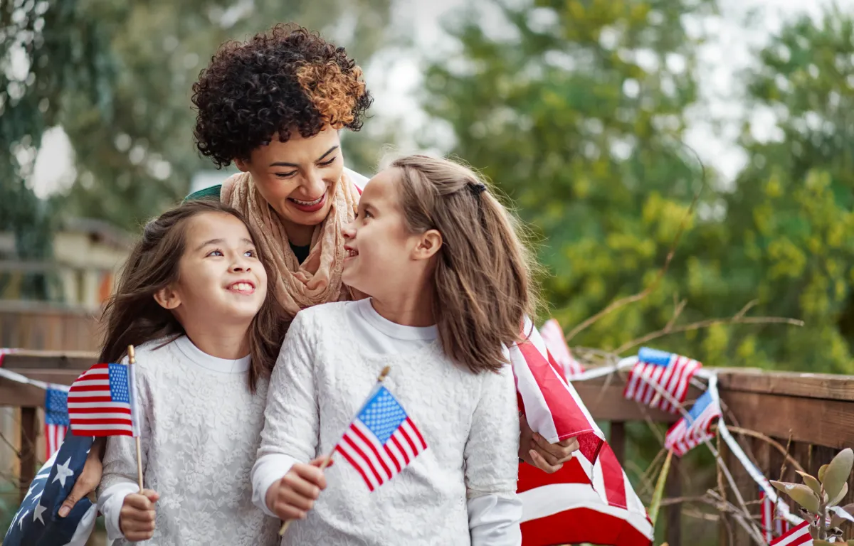 A mother and her daughters holding American flags